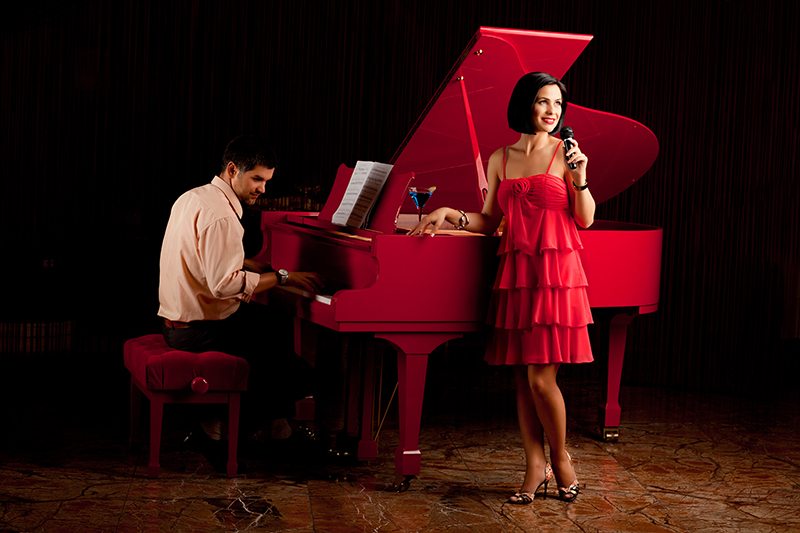 man playing piano and woman singing microphone